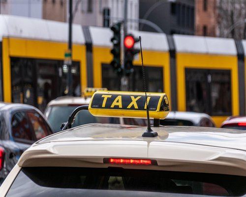 A person walking down a busy street towards public transport